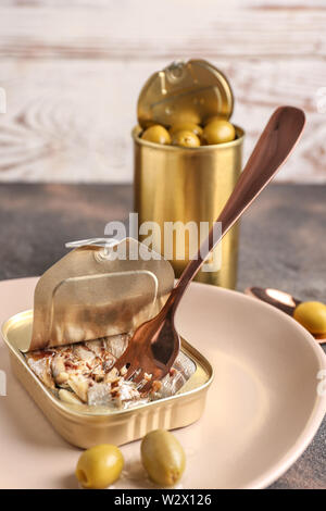 Les boîtes de conserve avec des anchois dans l'huile et olives marinées sur table Banque D'Images