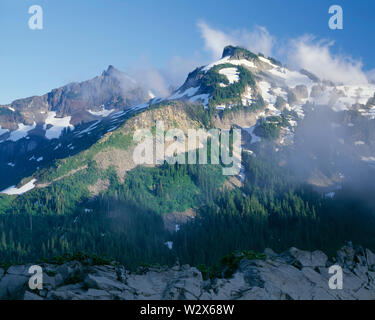USA, Washington, Mt. Rainier National Park, lumière du soir sur Unicorn Peak et d'autres sommets du Tatoosh Range en remuant, nuages. Banque D'Images