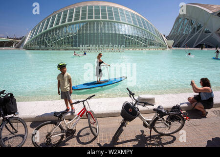 Valence, Espagne. 10 Juin, 2019. Les gens d'en profiter sur le lac en face de l'Hemisferic cinema au Arts & Science City à Valence.Arts et Science City est un divertissement culturel, sci-fi-style et d'architecture complexe dans la ville de Valence, en Espagne. C'est la plus importante destination touristique moderne dans la ville de Valence. Conçue par Santiago Calatrava et Félix Candela, le projet a commencé les premières étapes de construction en juillet 1996, et a été inauguré le 16 avril 1998 avec l'ouverture de l'HemisfÃ¨ric. Le dernier grand élément de la Cité des Arts et des Sciences, El Palau de les Arts Banque D'Images