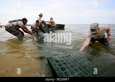 Les soldats de la Garde nationale de la Brigade 711 bataillon de soutien repose sur le rivage à l'intérieur du Dauphin Îles. Les barrières seront remplis de polymères qui transformer tout déversement d'huile dans un rubberlike solide. L'état de l'Alabama l'espoir d'éviter de graves dommages à l'île à partir de la marée noire provoquée par l'explosion de la plateforme Deepwater Horizon et éruption. Banque D'Images