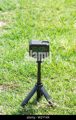 Appareil photo et vidéo avec petit stand noir sur sur l'herbe verte Banque D'Images