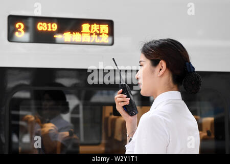 (190711) -- CHONGQING, 11 juillet 2019 (Xinhua) -- un membre du personnel travaille à côté de la puce G319 de train à la gare de l'ouest de Chongqing dans le sud-ouest de la Chine, Chongqing, le 11 juillet 2019. Le bullet train G319 a quitté la gare de l'ouest de Chongqing à 8 h 20 et arrivera à Hong Kong West Kowloon Station autour de 7,5 heures plus tard. Un siège de seconde classe pour les 7,5 heures de voiture coûte 660 yuans (environ 96 dollars américains). (Xinhua/Tang Yi) Banque D'Images