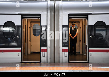 (190711) -- CHONGQING, 11 juillet 2019 (Xinhua) -- Un accompagnateur attend les passagers à bord du train rapide G319 à la gare de l'ouest de Chongqing dans le sud-ouest de la Chine, Chongqing, le 11 juillet 2019. Le bullet train G319 a quitté la gare de l'ouest de Chongqing à 8 h 20 et arrivera à Hong Kong West Kowloon Station autour de 7,5 heures plus tard. Un siège de seconde classe pour les 7,5 heures de voiture coûte 660 yuans (environ 96 dollars américains). (Xinhua/Tang Yi) Banque D'Images