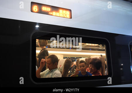 (190711) -- CHONGQING, 11 juillet 2019 (Xinhua) -- Un enfant de vagues à l'intérieur de la fenêtre du train rapide G319 à la gare de l'ouest de Chongqing dans le sud-ouest de la Chine, Chongqing, le 11 juillet 2019. Le bullet train G319 a quitté la gare de l'ouest de Chongqing à 8 h 20 et arrivera à Hong Kong West Kowloon Station autour de 7,5 heures plus tard. Un siège de seconde classe pour les 7,5 heures de voiture coûte 660 yuans (environ 96 dollars américains). (Xinhua/Tang Yi) Banque D'Images