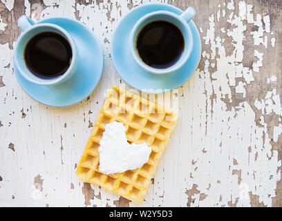 Gaufre belge et deux tasses de café sur une vieille table en bois Banque D'Images