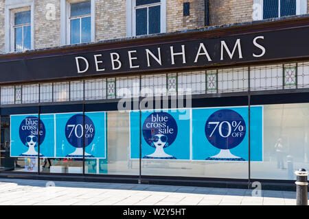 Magasin Debenhams shop avec la croix bleue la vente jusqu'à 70 % de rabais annoncés dans la fenêtre avant à la Winchester, Hampshire, Royaume-Uni en juillet Banque D'Images