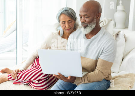 Couple à l'aide d'un ordinateur portable blanc Banque D'Images