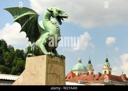 Le Dragon de statues dans le Dragon Bridge et Cathédrale de St Nicholas à l'arrière-plan dans le centre de Ljubljana, Slovénie Banque D'Images