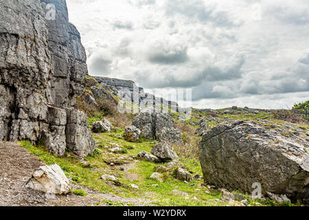 Paysage karstique du Burren plateau de Caher valley et tête noire, Geopark et sauvage de l'Atlantique géosites, Chemin, ciel nuageux jour de printemps Banque D'Images