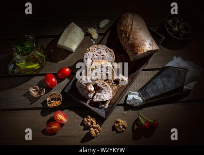 Breadtime avec al miche de pain, saucisses, charcuterie, cornichons, beurre de tomates et noix Banque D'Images