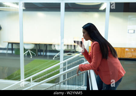 Businesswoman talking on mobile phone in corridor Banque D'Images