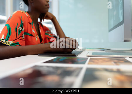 Graphiste femme travaillant sur tablette graphique at desk in office Banque D'Images