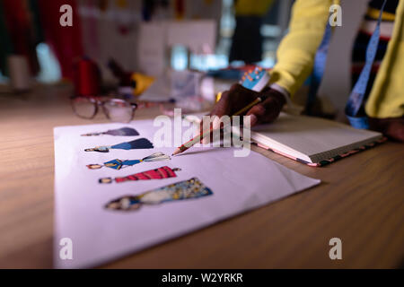 Designer de mode féminine à la recherche de croquis en design studio Banque D'Images