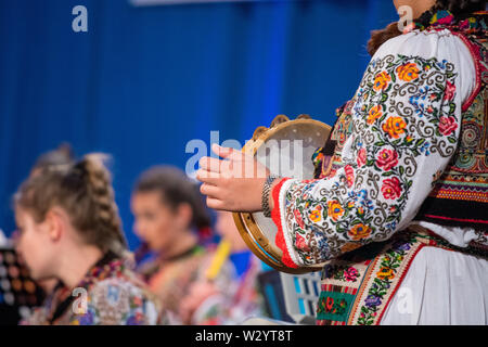 Close up de mains de jeune fille roumaine en costume folklorique traditionnel. Le folklore de Roumanie Banque D'Images