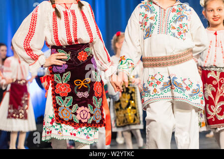 Les jeunes danseurs roumains effectuer une danse folklorique en costume folklorique traditionnel. Le folklore de Roumanie Banque D'Images