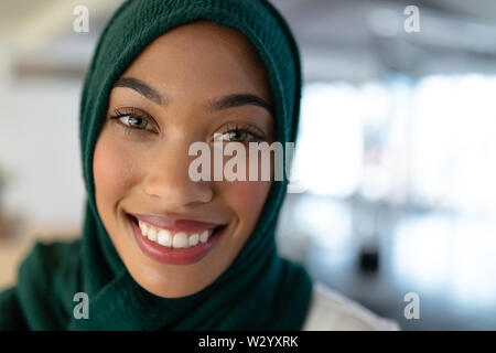 La femme en hijab standing in office Banque D'Images