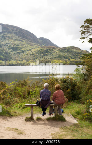 Un couple d'oeil au-dessus d'un lac dans le Parc National de Killarney, comté de Kerry, Irlande. Banque D'Images