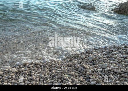 Plage de galets et mer peu profonde Banque D'Images