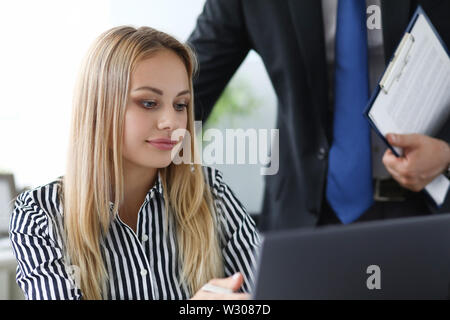 Portrait of concentrated businesswoman avec partenaire. Belle femme travaillant sur ordinateur portable au travail moderne. Biz et concept de l'entreprise. Blurred backgroun Banque D'Images