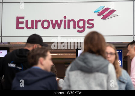 11 juillet 2019, Berlin, Düsseldorf : passagers attendent à un comptoir d'Eurowings. L'aéroport de Düsseldorf s'attend à ce que près de 3,9 millions de passagers pendant les vacances d'été. Photo : Federico Gambarini/dpa Banque D'Images