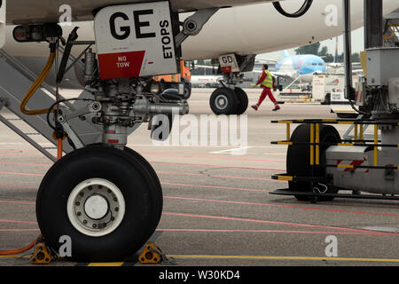 11 juillet 2019, Berlin, Düsseldorf : Un technicien passe devant un avion. L'aéroport de Düsseldorf s'attend à ce que près de 3,9 millions de passagers pendant les vacances d'été. Photo : Federico Gambarini/dpa Banque D'Images