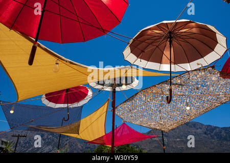 Parasols colorés sur fond de ciel bleu couvrant taverna terrasse dans village de Vasiliki, Crète, Grèce Banque D'Images
