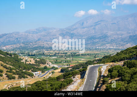 Route menant vers le bas en plaine de Lassithi avec montagnes Dikti, Crète, Grèce Banque D'Images