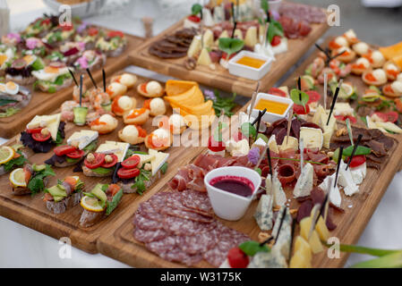 Grande sélection d'aliments contenant des collations froides, salades, charcuterie, fromage et confiture servi. Variété de délicieux en-cas savoureux sur la table. Réception de Mariage Banque D'Images