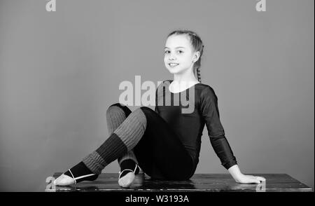 Séance de gym acrobatique de fille. La gymnastique. Heureux l'enfant sportif. Régime alimentaire de remise en forme. L'énergie. succès. L'activité de la petite enfance. Le sport et la santé. Avoir une petite pause. Libère ton esprit. Rêver d'avenir. Banque D'Images