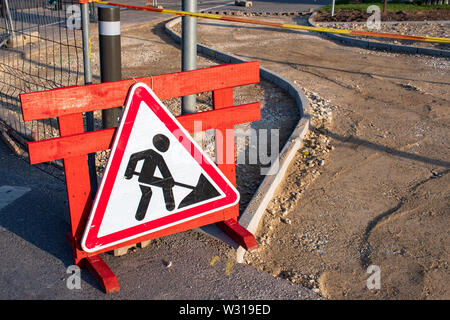 En construction. Les travaux en cours. Travaux routiers, de signalisation routière. L'homme au travail. La construction d'une nouvelle piste cyclable ou le trottoir Banque D'Images