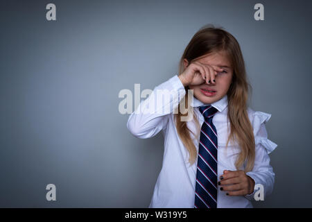 Petite lycéenne covering face, portrait de pleurer. Préadolescent a souligné, de peur d'essuyer l'enfant, cacher les larmes. Élève, étudiant à l'uniforme scolaire. Retour à sc Banque D'Images