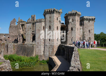 Visiteurs en face de la grande maison de gardien à Raglan castle, Monmouthshire, Wales, UK Banque D'Images