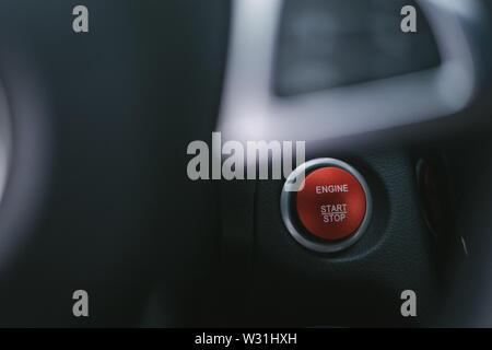 L'accent sur le bouton start stop rouge en voiture avec volant non focalisé Banque D'Images