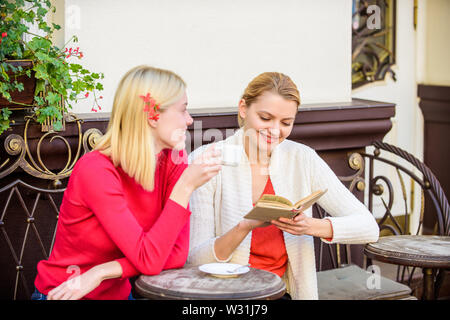 La littérature féminine. Lecture livre inspirant. L'amélioration d'individu et de l'éducation. Discuter de librairie populaire. Réserver chaque fille devrait lire. Girls friends sitting café terrasse boire du café. Banque D'Images