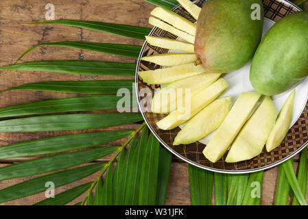 Les tranches de mangue verte sur table en bois vue ci-dessus Banque D'Images