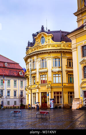 Sibiu, Roumanie - 27 mars 2015 : les maisons et les gens qui marchent au temps pluvieux au main square à Sibiu, Transylvanie, Roumanie Banque D'Images