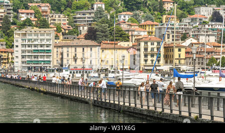Côme, Italie - Juin 2019 : Les gens de marcher sur la promenade qui s'étend dans le port à Côme sur le lac de Côme. Banque D'Images