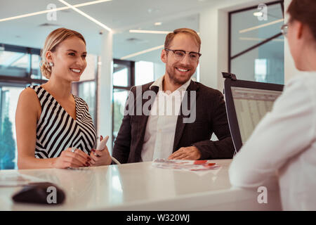 Smiling blonde woman restant avec son barbu sur une réception Banque D'Images