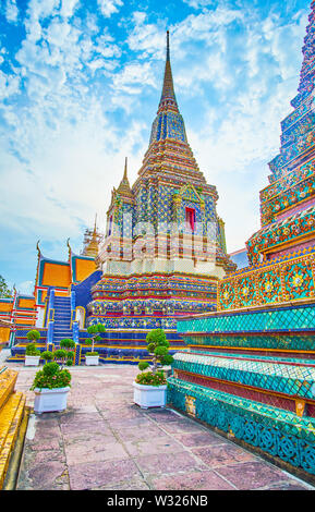 Promenade dans le Wat Pho le splendide complexe sol carrelé stupas de Phra Maha Chedi de culte en thai-style chinois, Bangkok, Thaïlande Banque D'Images