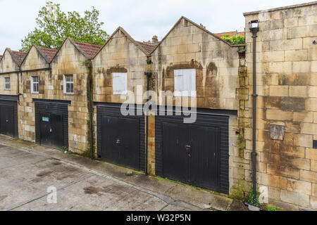 Rangée de bâtiments historiques stables à pignons maintenant utilisé comme les garages de verrouillage à Bath, la plus grande ville de Somerset, au sud-ouest de l'Angleterre, Royaume-Uni Banque D'Images