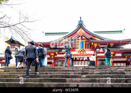 Tokyo, Japon - 30 mars 2019 : Sanctuaire Shinto Hie avec marches de pierre ou les escaliers et personnes à pied par l'entrée du temple Banque D'Images