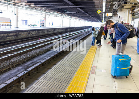 Utsunomiya, Japon - 4 Avril, 2019 : plate-forme de la gare de Nikko et de ligne locale architecture sombre couvert avec de nombreuses personnes par les voies d'attente Banque D'Images