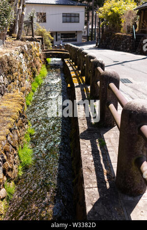 Nikko, Japon vue de canal river dans les montagnes avec petit pont de pierre dans la préfecture de Tochigi au Japon avec de l'eau bleu au début du printemps Banque D'Images