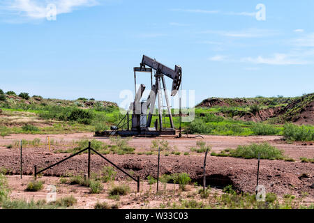 Pumpjack sur les gisements en prairies de poster, au Texas, avec pompage pendant la journée de l'huile de la machine Banque D'Images