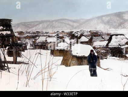 [ 1890 - Japon village ainu, Hokkaido ] - Une femme aïnou se tient dans la neige. Derrière elle un village ainu est visible. 19e siècle vintage lame de verre. Banque D'Images