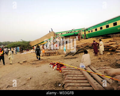 (190712) -- BEIJING, 12 juillet 2019 (Xinhua) -- Photo prise avec un téléphone portable montre aux gens et les sauveteurs qui travaillent à l'accident de train dans l'est du Pakistan site Ville de Rahim Yar Khan le 11 juillet 2019. Un train de voyageurs a enfoncé dans un train de marchandises à l'est du Pakistan ville de Rahim Yar Khan, le jeudi matin, tuant 13 personnes et blessant 70 autres, ont déclaré. Agent de police du district de Rahim Yar Khan Umar Farooq Salamat a dit que les femmes et les enfants sont parmi les personnes décédées. (Str/AFP) Banque D'Images