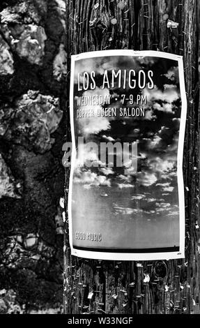 Une photo d'une affiche pour la publicité cloudscape band, "Los Amigos", affiché sur un poteau d'éclairage en bois avec des centaines d'autres agrafes et clous Banque D'Images