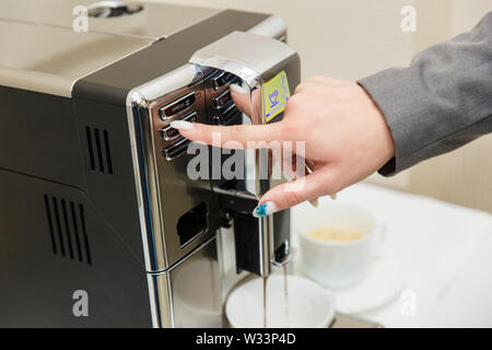 Machinne café verse du café fraîchement moulu dans la tasse blanche. Banque D'Images