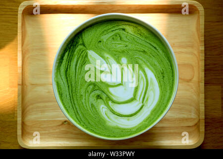 Vue de dessus d'une tasse de thé vert matcha Latte sur plateau en bois naturel Banque D'Images