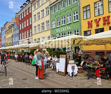 Copenhague, Danemark - 16 juin, 2019 personnes place à l'un des nombreux restaurants du front de mer du port de Nyhavn, célèbre monument touristique et entertainme Banque D'Images